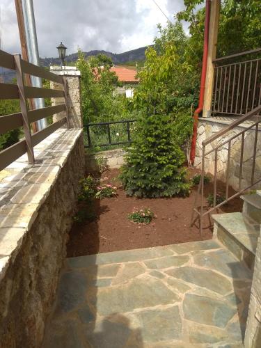 a stone retaining wall next to a patio with a garden at Angelic in the mountains in Kaisárion