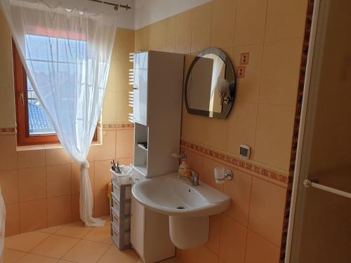 a small bathroom with a sink and a mirror at Apartamenty i pokoje u Beaty in Augustów