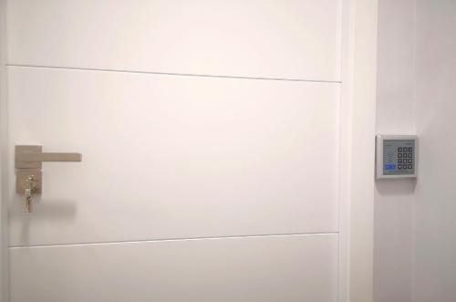 a white cabinet with a clock on it at ERES EMÉRITA "Apartamentos & Suites" in Merida