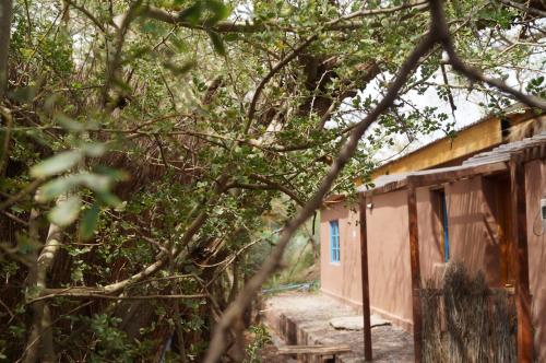 an old building with a blue door in the trees at Atacama Lodge Rukazen Rústico in San Pedro de Atacama