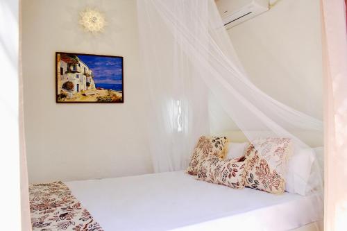 a white bedroom with a bed with a curtain at Casa Klod Ibiza in Ibiza Town