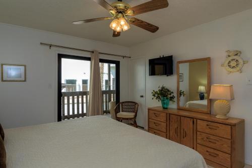 una camera con letto e ventilatore a soffitto di Tiki 218 a South Padre Island