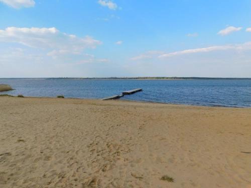 a beach with a dock in the middle of the water at Agroturystyka Ruta nad zalewem Siemianówka in Łuka