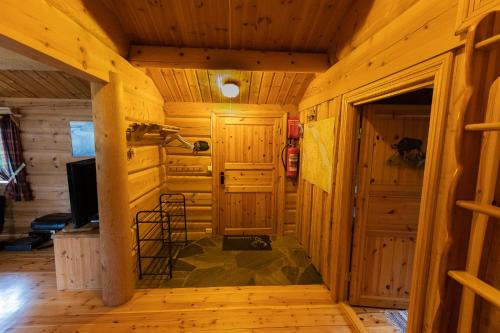 a log cabin hallway with a television and a room at Sunndalsfjord Cottages Fredsvik Meisalstranda 455,506 og 508 in Sunndalsøra