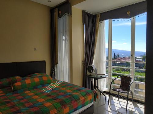 a bedroom with a bed and a large window at Villa Gumilang in Batu