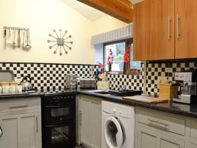 a kitchen with a washer and dryer in it at The Granary in Swansea