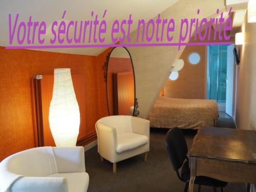 Cette chambre comprend un lit, une table et un miroir. dans l'établissement Hôtel La Villa Lorraine, à Toul