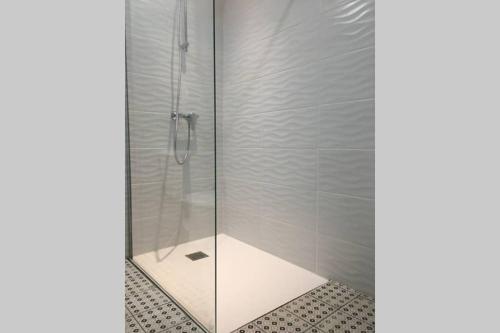 une douche avec une porte vitrée dans une salle de bain dans l'établissement Le jardin des Capucins, à Carcassonne