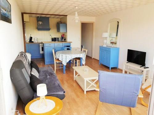 a living room with a couch and a table at Appartement sur le port du Crotoy vue Baie de Somme in Le Crotoy