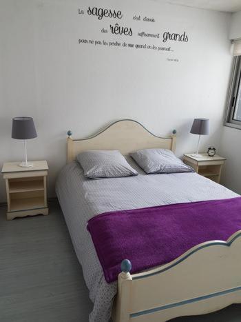 1 dormitorio con 1 cama con manta morada en Appartement sur le port du Crotoy vue Baie de Somme en Le Crotoy