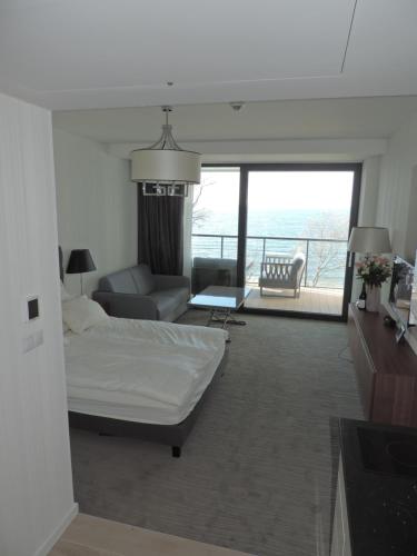 ein Schlafzimmer mit einem Bett und ein Wohnzimmer in der Unterkunft Apartament 514 Seaside z widokiem na morze in Kołobrzeg