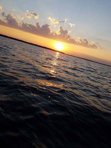 a sunset over a body of water with the ocean at Agroturystyka Ruta nad zalewem Siemianówka in Łuka