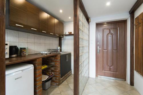 a kitchen with wooden cabinets and a door in a room at Gorgeous loft in perfect location! in Krakow