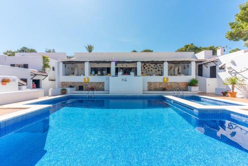 una villa con piscina e una casa di Hostal Cala Moli a Cala Tarida