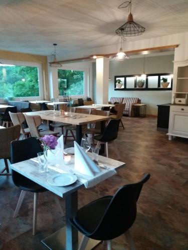 a restaurant with tables and chairs in a room at Haus S.E.E. in Marienthal