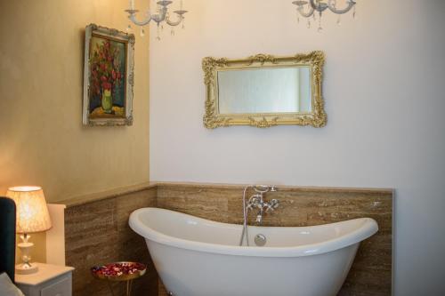 baño con bañera y espejo en la pared en Ultracentral luxury apartment, en Cluj-Napoca