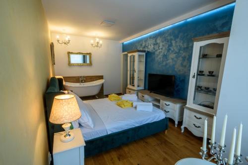 ein Schlafzimmer mit einem Bett, einer Badewanne und einem TV in der Unterkunft Ultracentral luxury apartment in Cluj-Napoca
