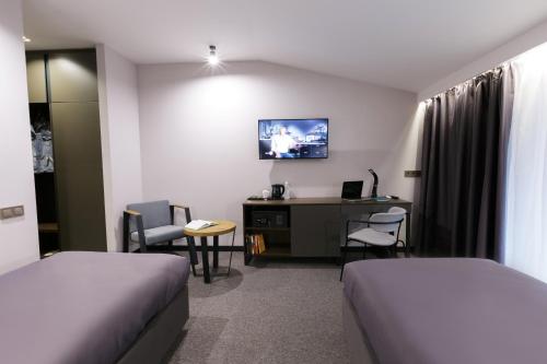 a hotel room with two beds and a desk at Kulikovskiy hotel in Kharkiv