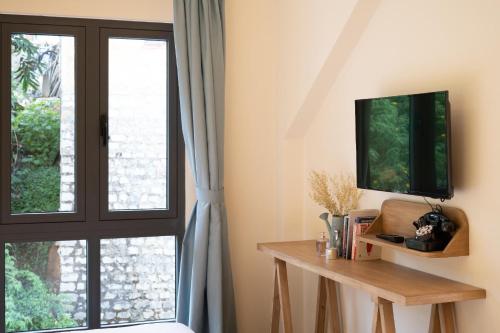 a room with a window with a tv and a table at La Em Boutique Villa in Da Lat