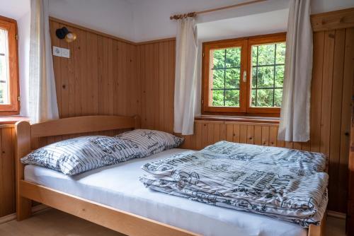 a bedroom with a bed in a room with windows at Holiday Home Srednja vas in Srednja Vas v Bohinju
