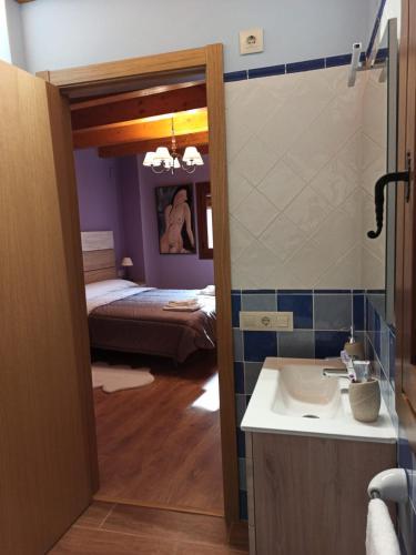 a bathroom with a sink and a room with a bed at La Caseta in Forcall