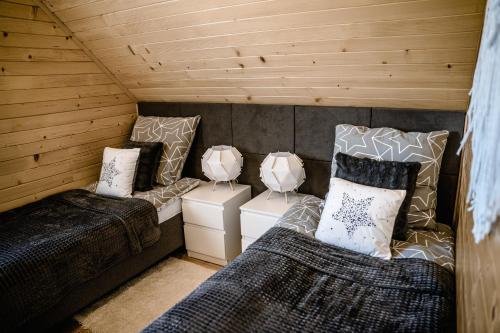 een kamer met 2 bedden en 2 kamers in een hut bij Sielskie Chatki in Sandomierz