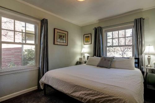 a bedroom with a bed and two windows at Drake Cottage 311 in Bend