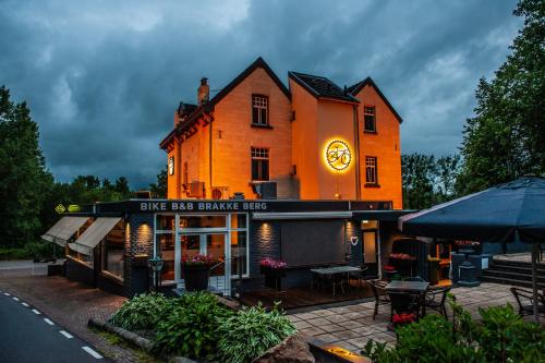 an orange building with a clock on the side of it at B&B Brakke Berg in Berg en Terblijt