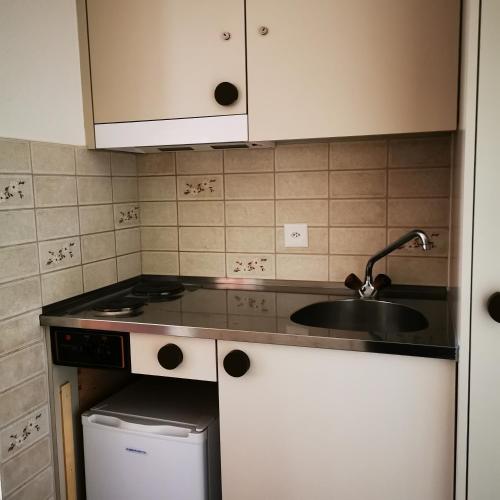 a small kitchen with a sink and a stove at FeWo Fernsicht Crystal in Adelboden