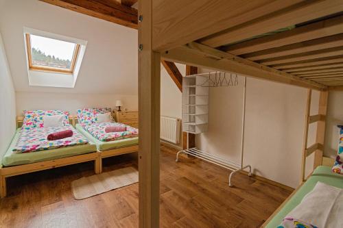 a bedroom with two bunk beds and a window at Apartman Charlie in Smržovka