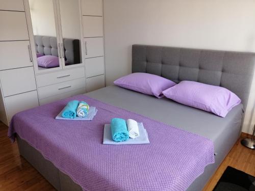a bedroom with a purple bed with towels on it at Apartment Mery in Trogir