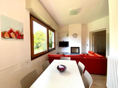 sala de estar con sofá rojo y mesa en Vittoria Residence, en Dongo