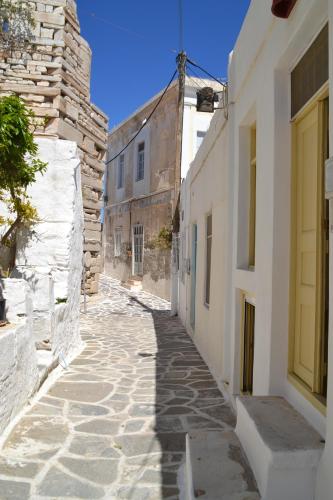 an alley in an old town with white buildings at Kastro in Parikia
