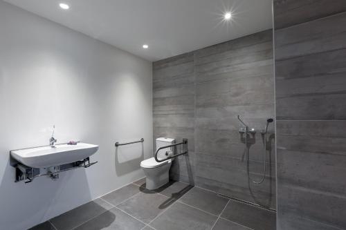 a bathroom with a toilet and a sink and a shower at Three House Hotel in Funchal