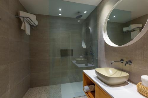 a bathroom with a sink and a shower with a mirror at Three House Hotel in Funchal