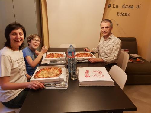 a group of people sitting at a table with pizzas at La casa di Edone in Monzambano
