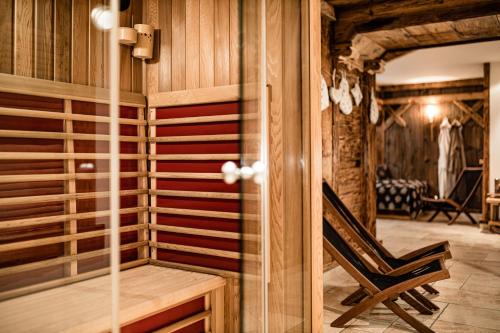 Cette chambre dispose d'un sauna avec une chaise. dans l'établissement Giardin Boutique Hotel B&B, à Selva di Val Gardena