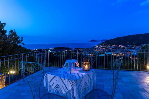 una mesa y sillas en un balcón por la noche en Borgo dell'Uccellaia - Smeraldo - Ametista en Marciana Marina