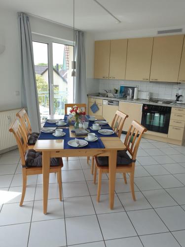a dining room table with chairs and a blue table cloth at Ferienwohnung Sonnenblick mit 3 Zimmer und Balkon in Zempin