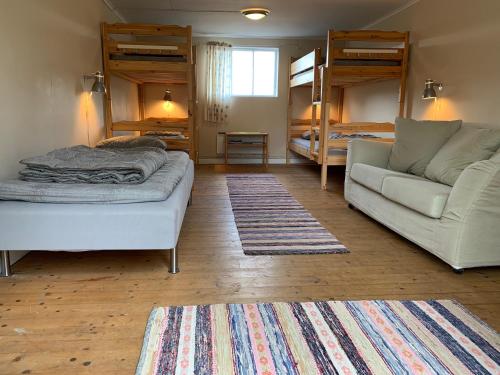 ein Wohnzimmer mit einem Sofa und Etagenbetten in der Unterkunft Asa Vandrarhem in Lammhult