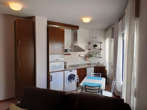 a kitchen with a couch and a table in a room at Apartamento Playa de Coira II in Portosin