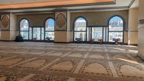 a man sitting in a room with a view of a building at InterContinental Dar Al Tawhid Makkah by IHG in Makkah
