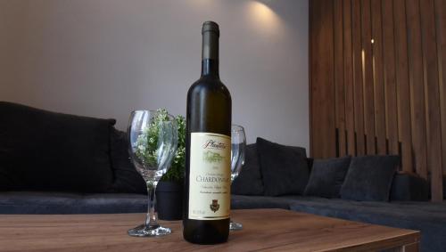 - une bouteille de vin assise sur une table avec 2 verres à vin dans l'établissement TASOS, à Belgrade