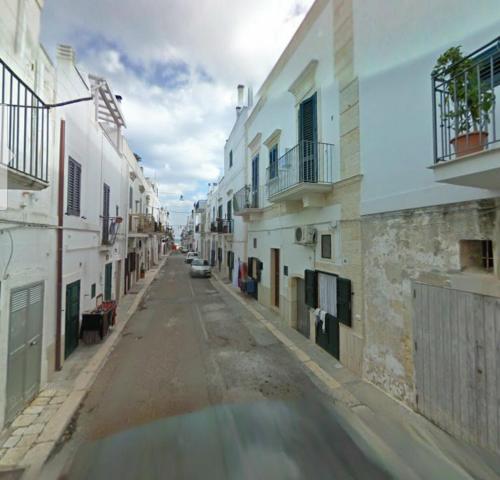 una strada vuota in una città con edifici bianchi di Casa Kale' a Polignano a Mare