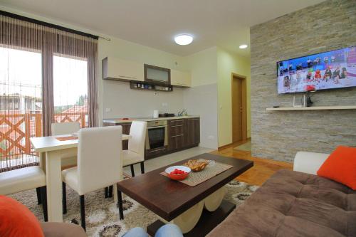 een woonkamer met een bank en een tafel bij Zlatiborska Vila 1 Lux in Zlatibor