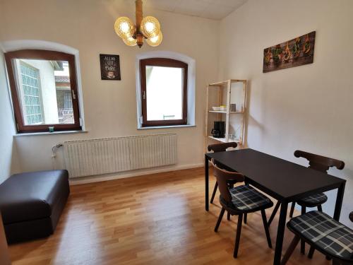 een woonkamer met een zwarte tafel en stoelen bij Klein aber fein! in Emskirchen
