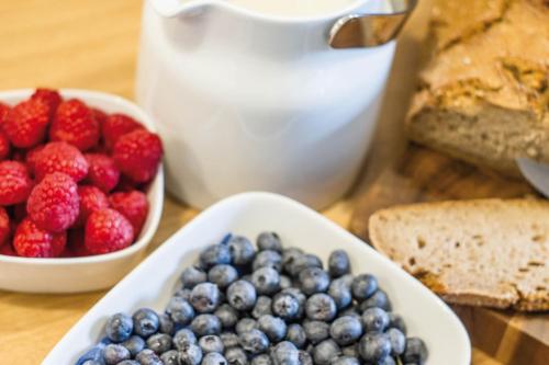 einen Tisch mit einer Schüssel Beeren und einer Schüssel Brot in der Unterkunft Hof Hallenberg in Hallenberg