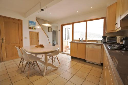 une cuisine avec une table et des chaises dans une cuisine dans l'établissement Appartement Le Grenadier, à Cotignac