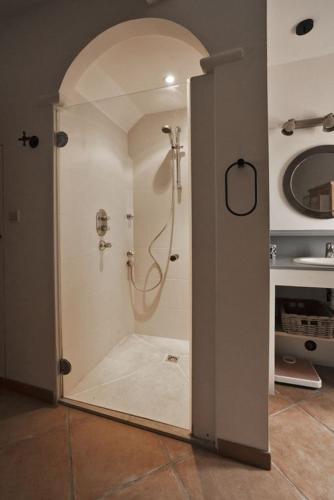 une salle de bain avec une douche avec une porte vitrée dans l'établissement Appartement Le Grenadier, à Cotignac