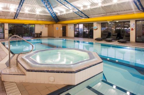 une grande piscine avec un bain à remous dans l'établissement Holiday Inn Rochester-Chatham, an IHG Hotel, à Chatham